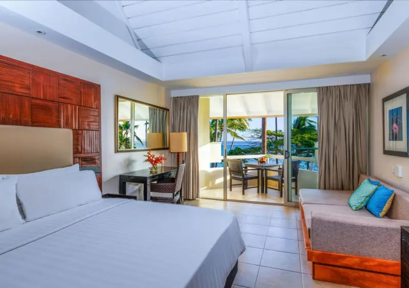 Une chambre lumineuse avec un grand lit et un accès à une terrasse.