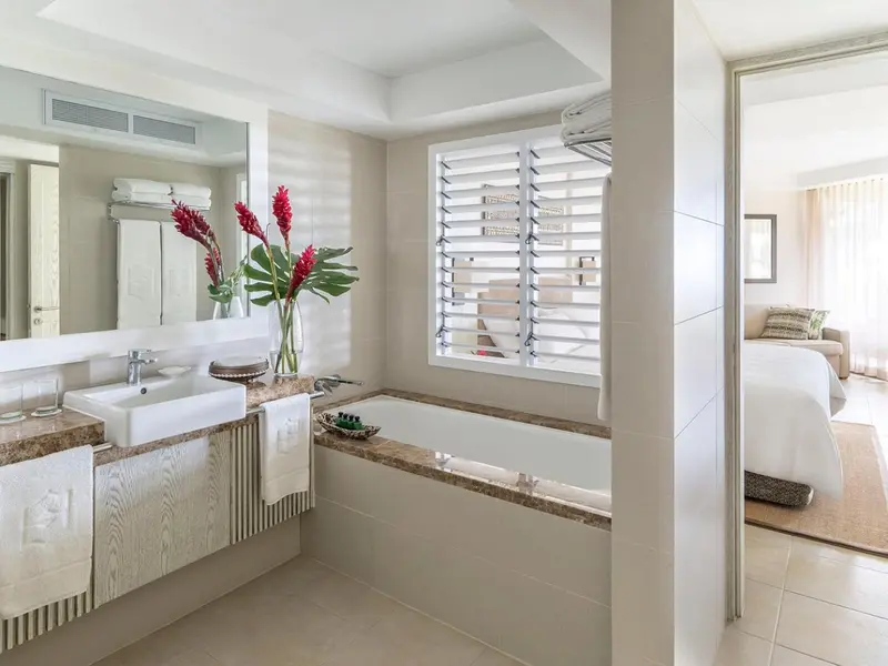 Une salle de bain lumineuse avec baignoire et vasque en marbre.