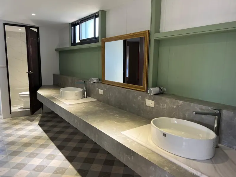 Une salle de bain moderne avec deux vasques et un grand miroir.