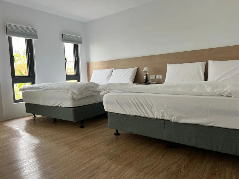 Une chambre lumineuse avec deux lits simples et une décoration sobre.