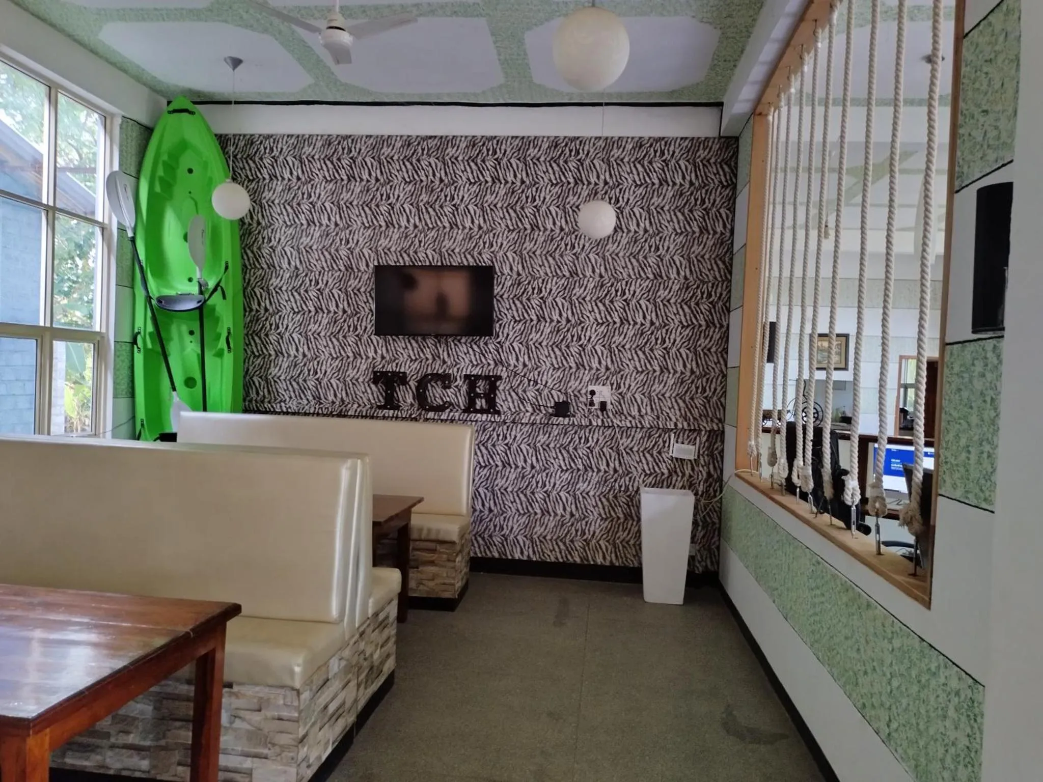 Espace de détente intérieur avec banquettes et décorations murales.