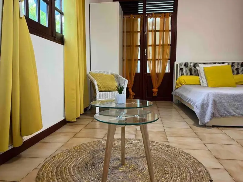 Une chambre lumineuse avec un coin salon et un lit.