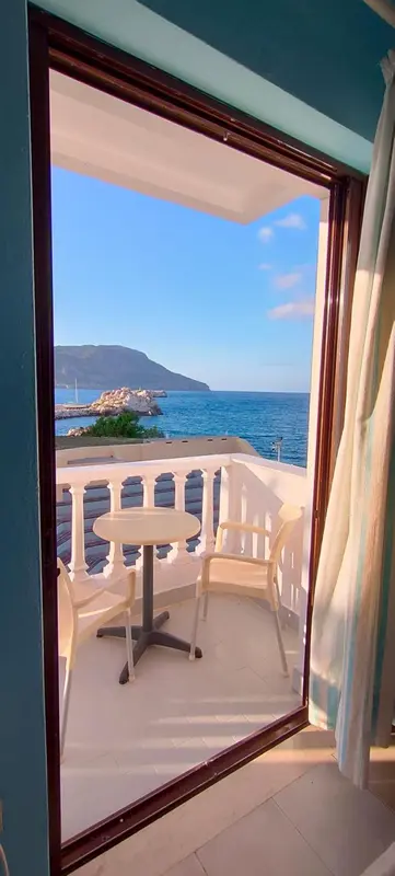 Vue sur la mer depuis un balcon avec mobilier d'extérieur.