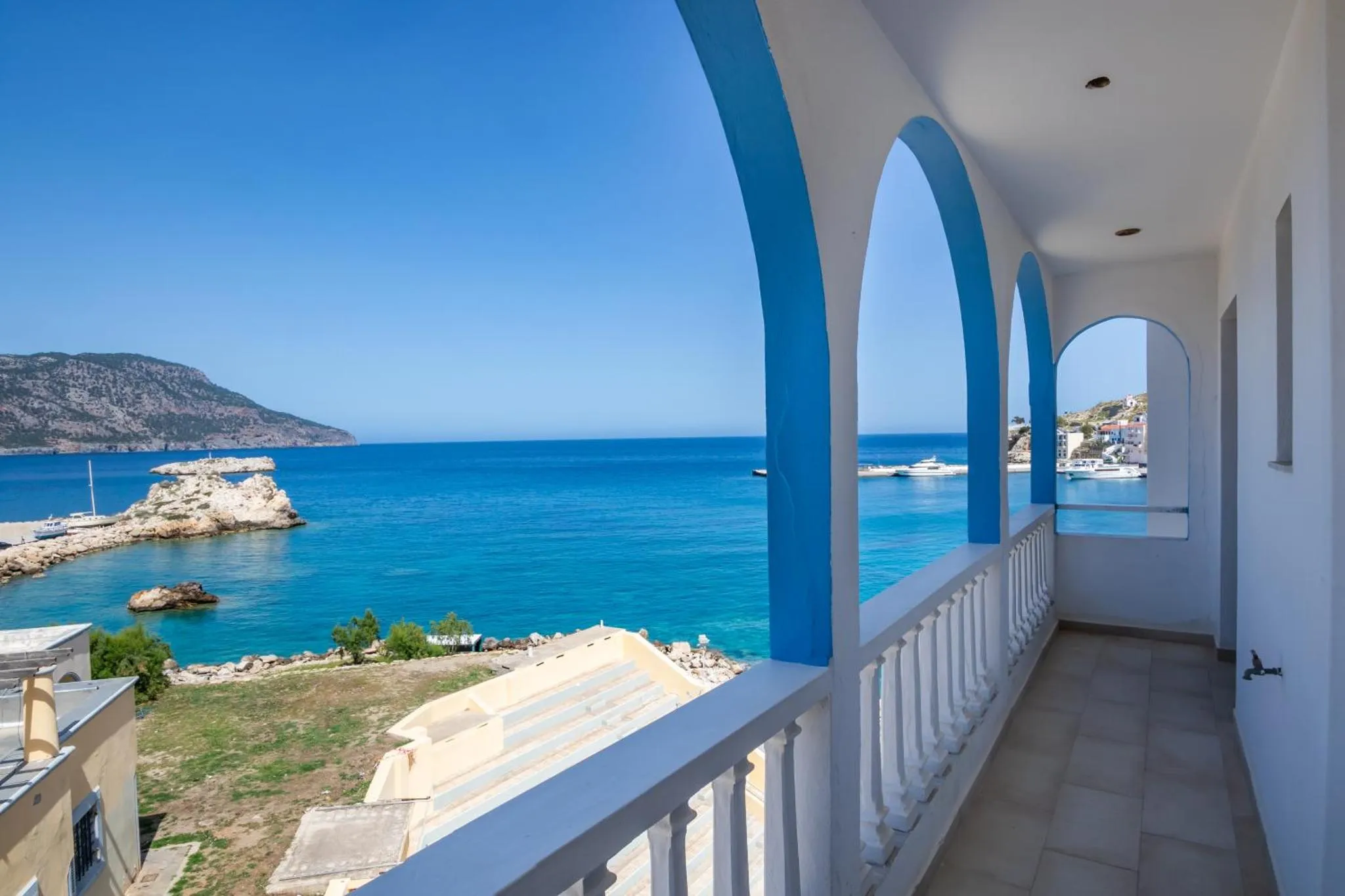 Vue sur la mer depuis une terrasse ensoleillée.