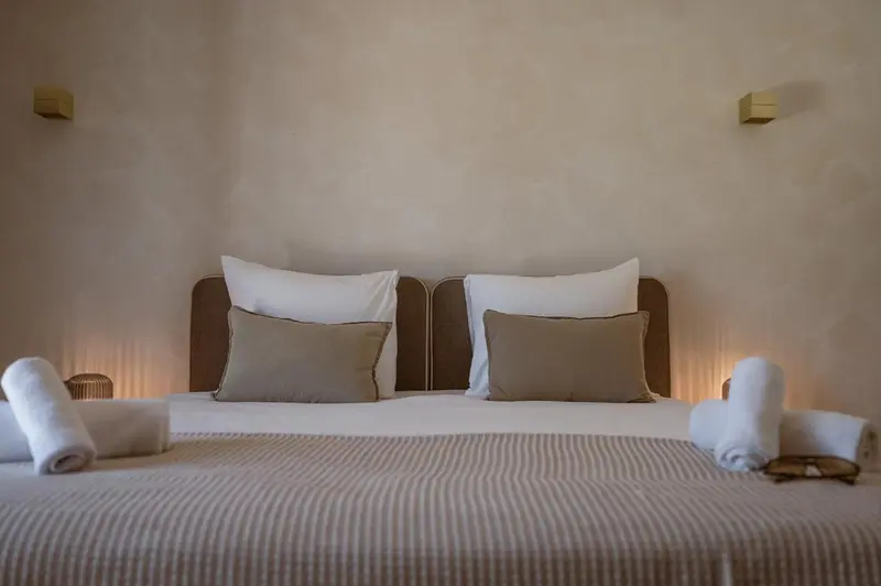 Un lit double avec oreillers et coussins dans une chambre lumineuse.