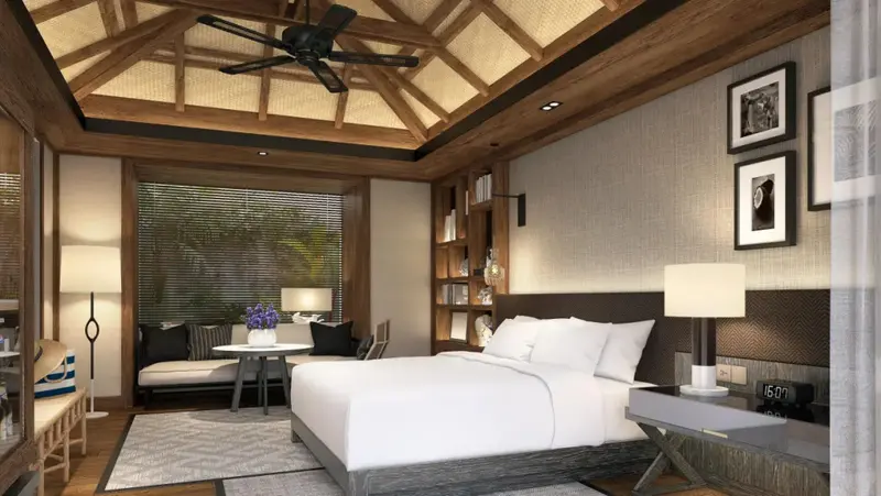 Une chambre lumineuse avec un grand lit et un espace salon.