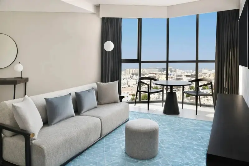 Un salon moderne avec canapé et table basse offre une vue sur la ville.