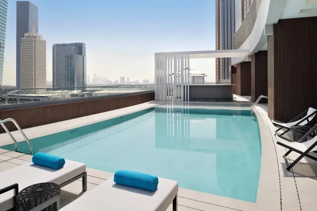Une piscine rectangulaire avec des transats sur une terrasse ensoleillée.