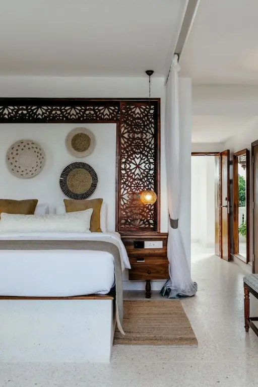 Une chambre lumineuse avec un grand lit et des décorations murales.