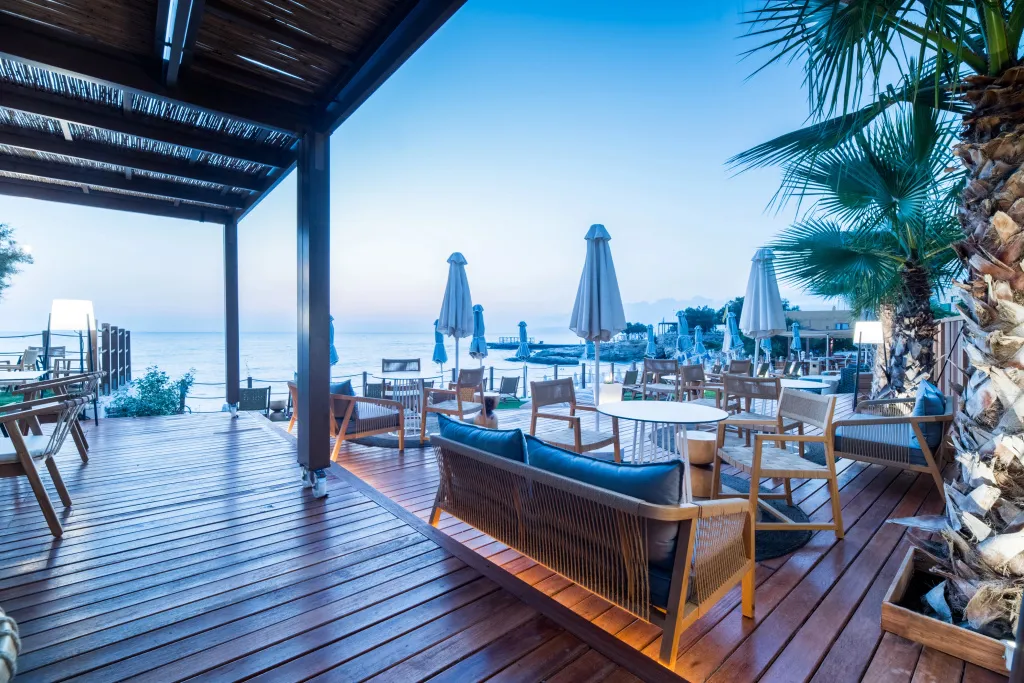 Terrasse en bois avec mobilier de détente face à la mer.
