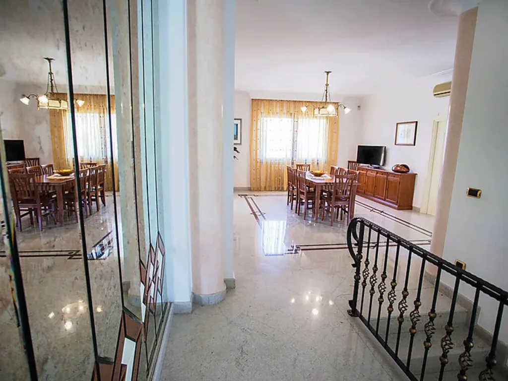 Une salle lumineuse avec de grandes tables à manger en bois et des lustres.