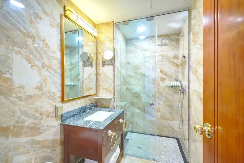 Une salle de bain lumineuse avec une douche à l'italienne et un meuble-lavabo en bois.
