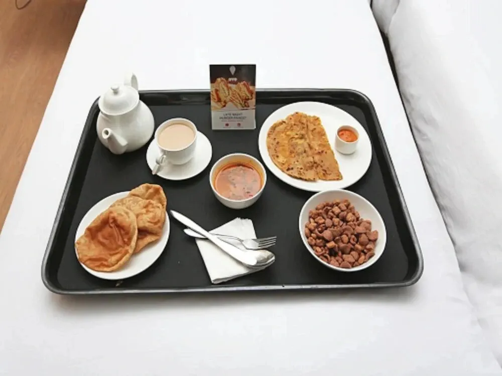 Un plateau repas est présenté sur un lit blanc.