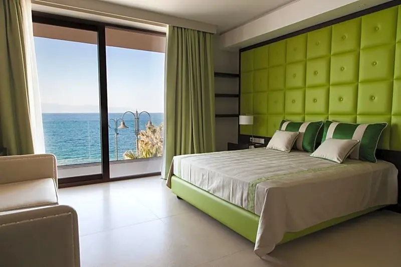 Une chambre lumineuse avec un grand lit et une vue sur la mer.