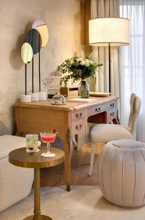 Une coiffeuse en bois clair est mise en valeur par des miroirs et un éclairage doux.