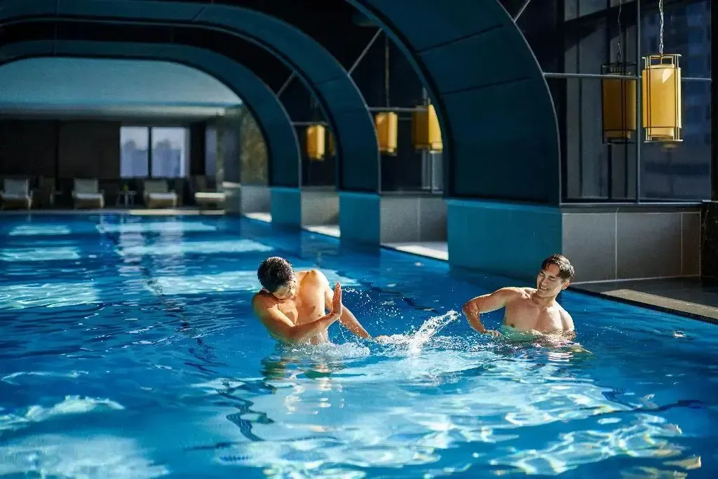 Deux personnes s'amusent dans une piscine intérieure.