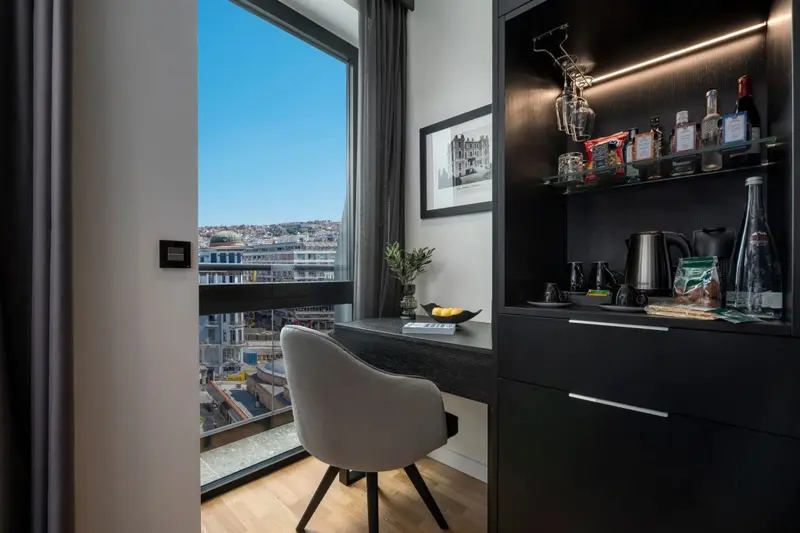 Une chaise design est placée devant un bureau avec une vue sur la ville.