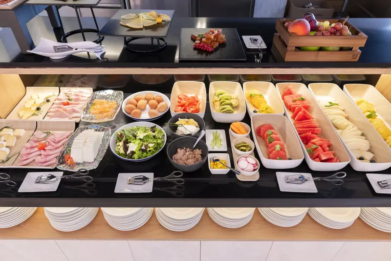Un buffet propose une variété de plats froids et de fruits frais.