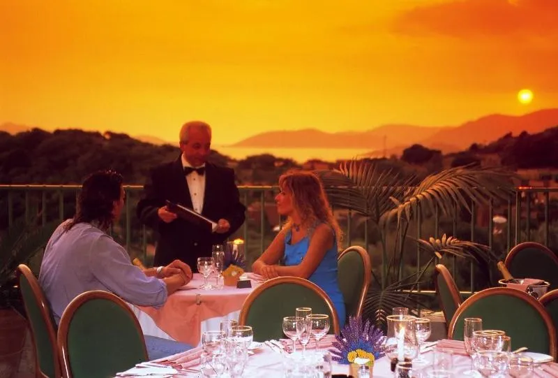 Une table de restaurant en extérieur avec vue sur un coucher de soleil.