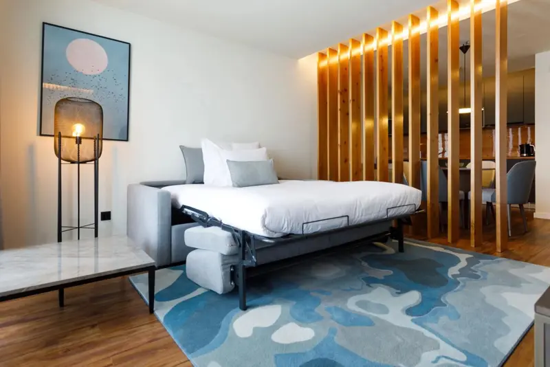 Une chambre moderne avec un lit fait et une cloison en bois.