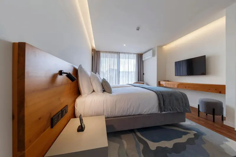 Une chambre lumineuse avec un grand lit et une décoration moderne.