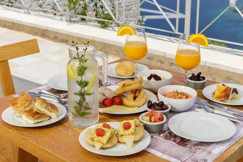 Une table en bois est dressée avec un copieux petit-déjeuner.