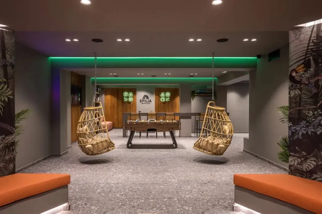 Espace de détente intérieur avec des fauteuils suspendus et un baby-foot.