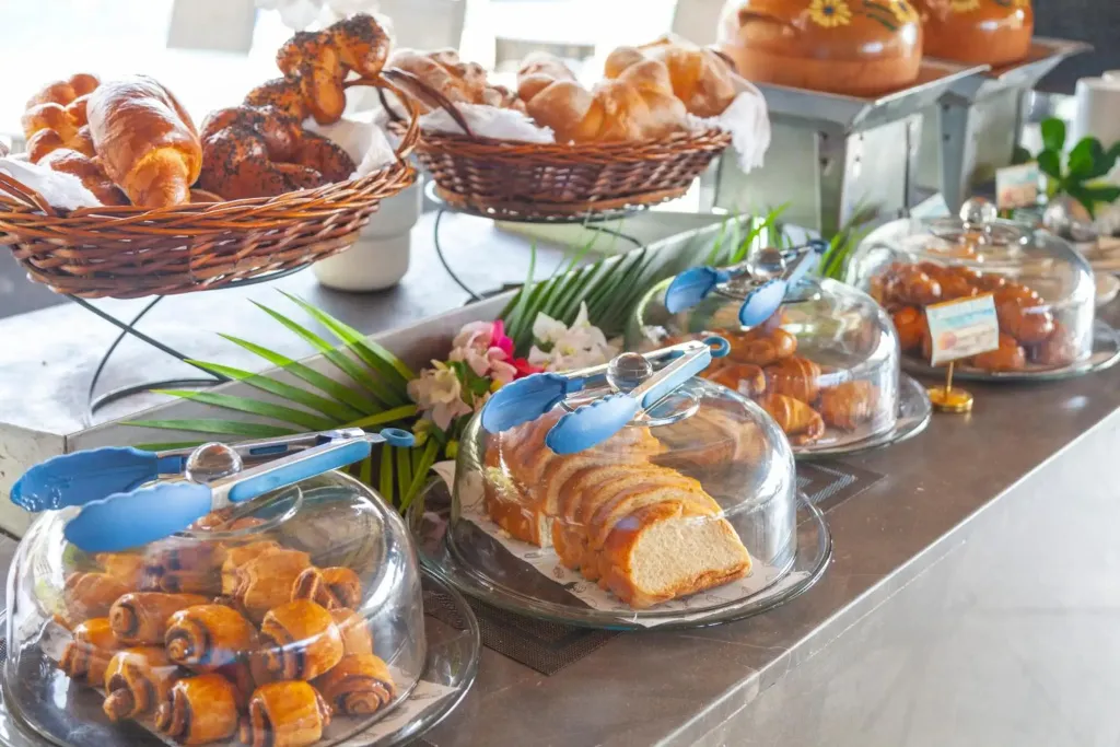 Un buffet propose une variété de viennoiseries et de pâtisseries.