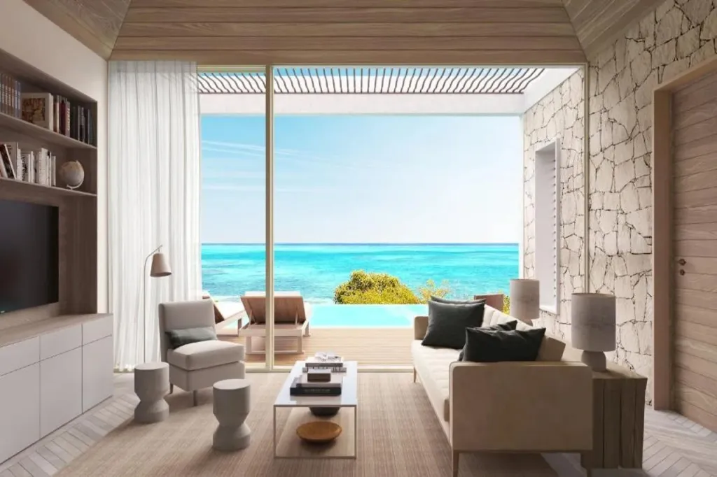 Un salon lumineux s'ouvre sur une terrasse avec piscine et vue sur la mer.