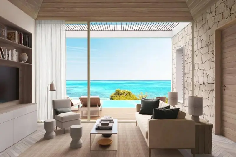 Un salon lumineux s'ouvre sur une terrasse avec piscine et vue sur la mer.