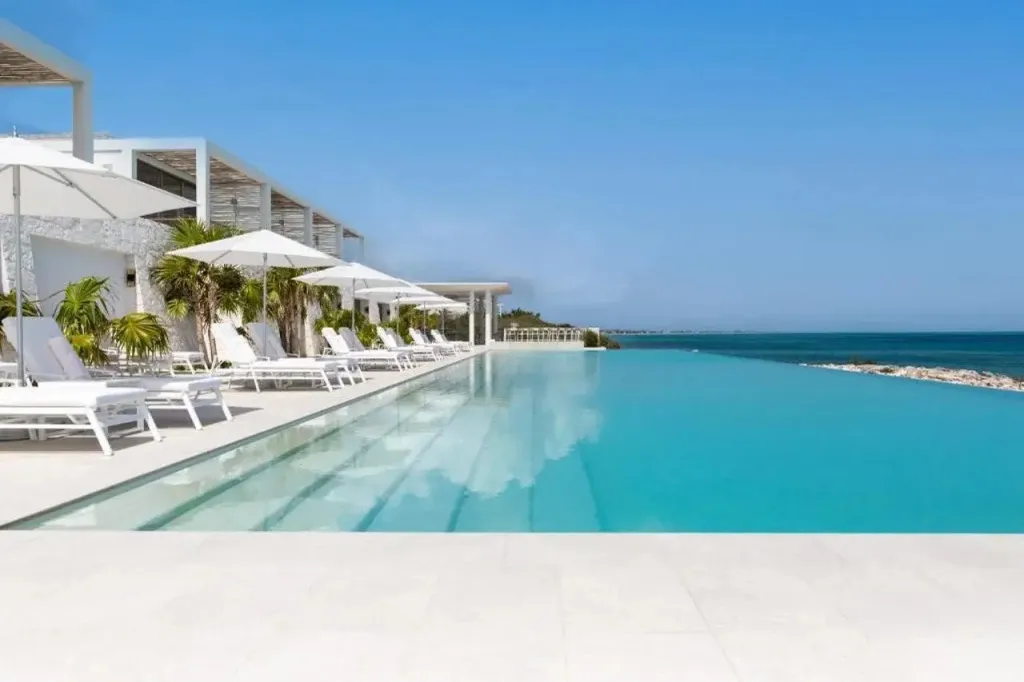 Une piscine à débordement offre une vue sur la mer et des transats invitent à la détente.