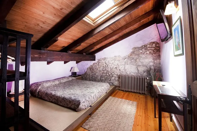 Une chambre mansardée avec un lit et un bureau.