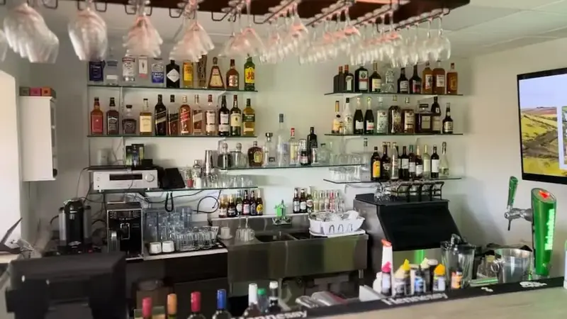 Un comptoir de bar bien garni présente une variété de bouteilles et de verres.