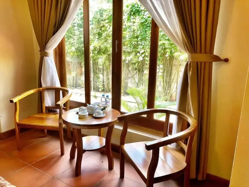 Espace de détente avec deux fauteuils et une table basse près d'une fenêtre.