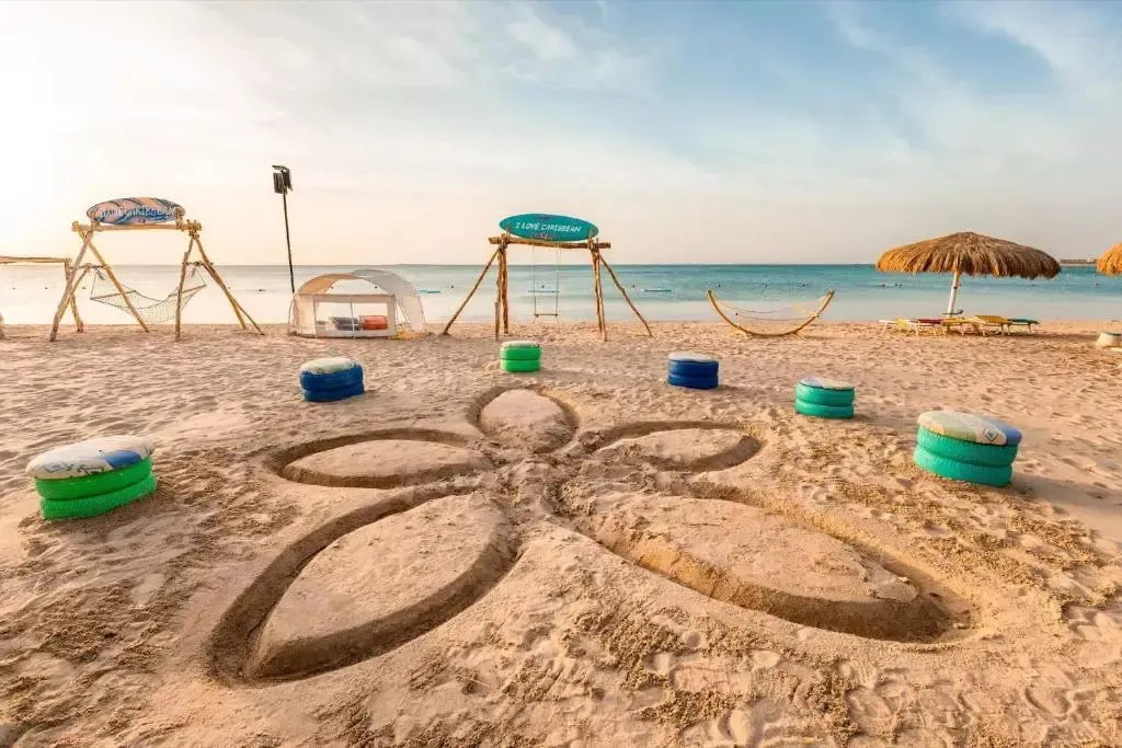 Plage de sable fin avec des sièges colorés et des structures de détente.
