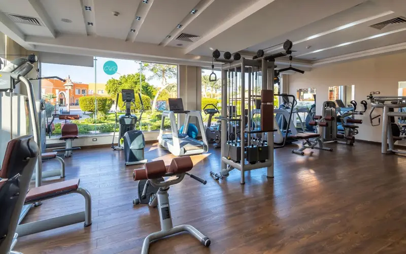 Une salle lumineuse est équipée de divers appareils de musculation et de cardio.