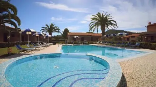 Piscine extérieure avec transats et parasols dans un cadre verdoyant.