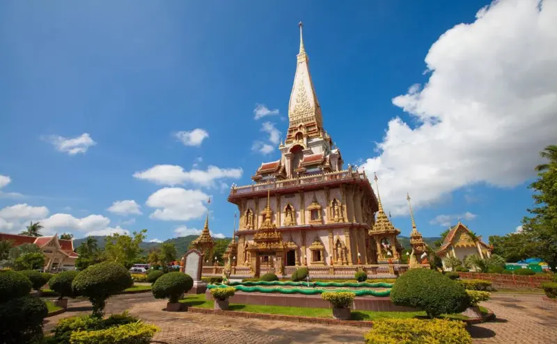 Architecture ornementée d'un temple sous un ciel bleu nuageux.