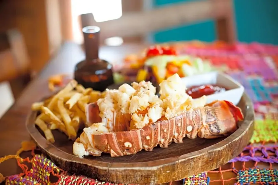 Un plat de homard grillé est servi avec des frites et une salade.