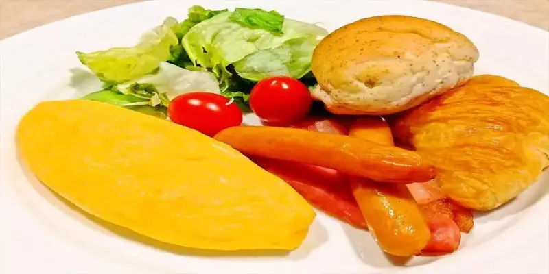 Assiette composée avec une portion de légumes, de la viande et du pain.
