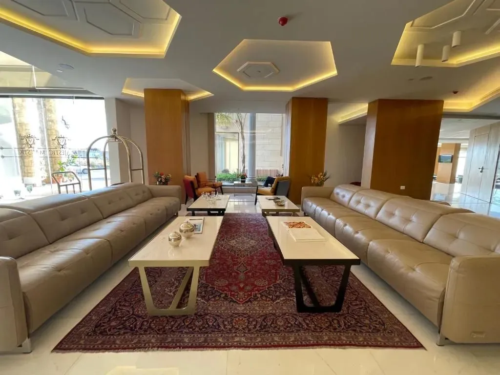 Un espace de détente lumineux avec des canapés et des tables basses sur un tapis.