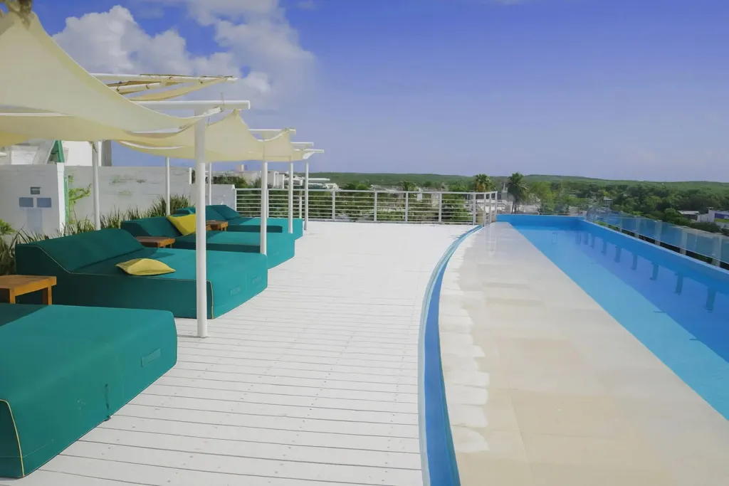 Terrasse aménagée avec des salons et une piscine à débordement.