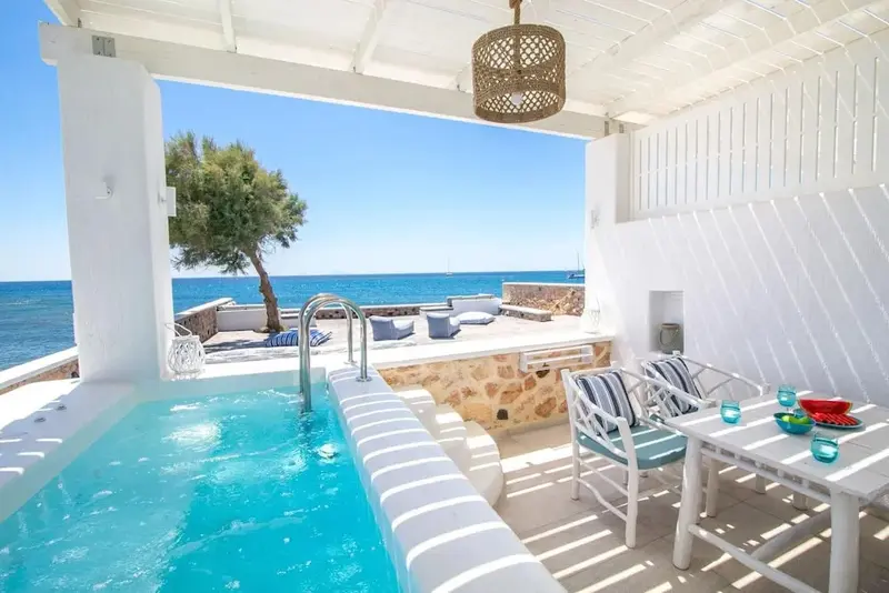 Espace extérieur aménagé avec jacuzzi et mobilier de jardin face à la mer.