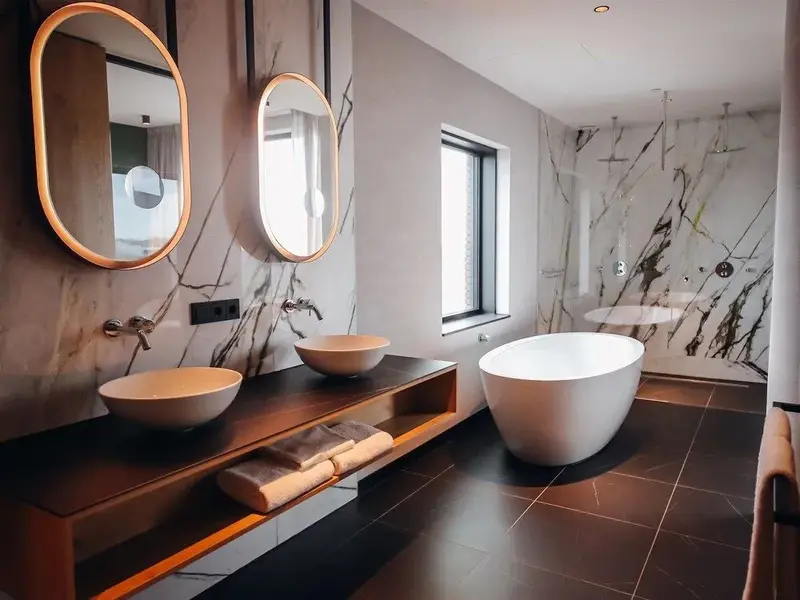 Une salle de bain moderne avec deux vasques et une baignoire îlot.