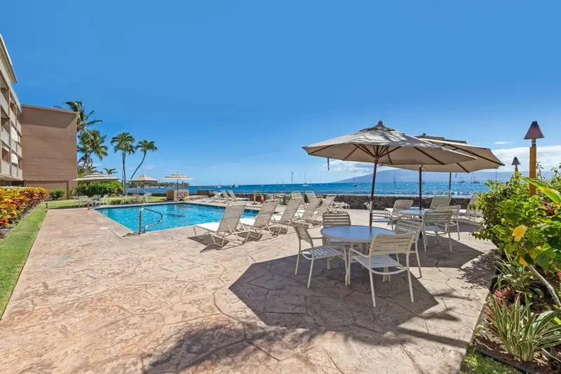 Terrasse avec mobilier de jardin et piscine au bord de la mer.