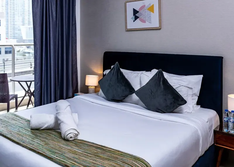 Une chambre lumineuse avec un grand lit et une décoration sobre.