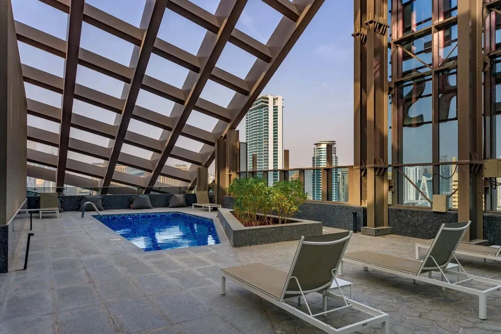 Terrasse avec piscine et mobilier de détente.