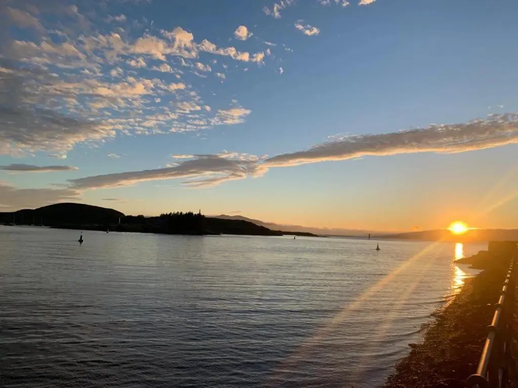 Coucher de soleil sur l'eau avec des îles en arrière-plan.