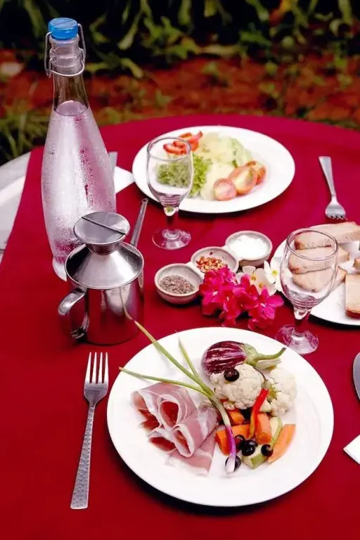 Une table dressée présente des plats variés et une bouteille d'eau.