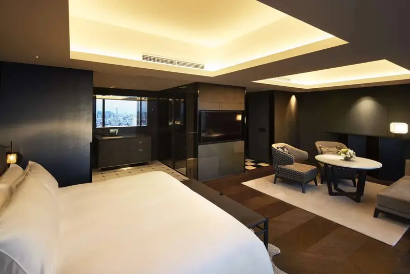 Une chambre moderne avec un grand lit et un espace salon.